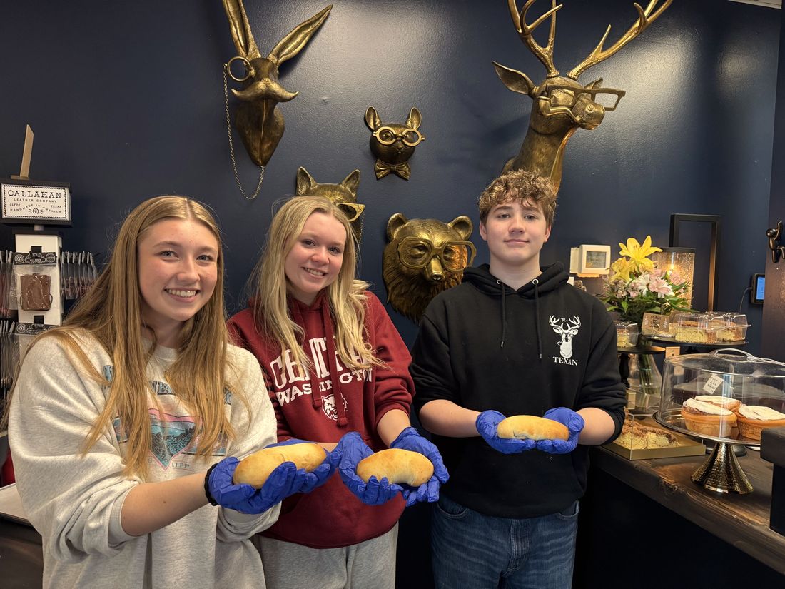 Texan team members holding fresh-baked cookies