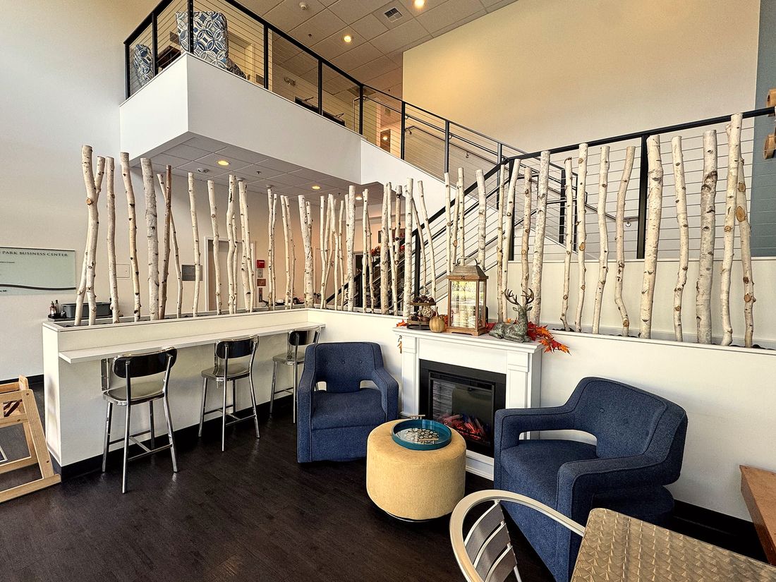 Inside The Texan café, with birch trees along the wall and seats by the fireplace